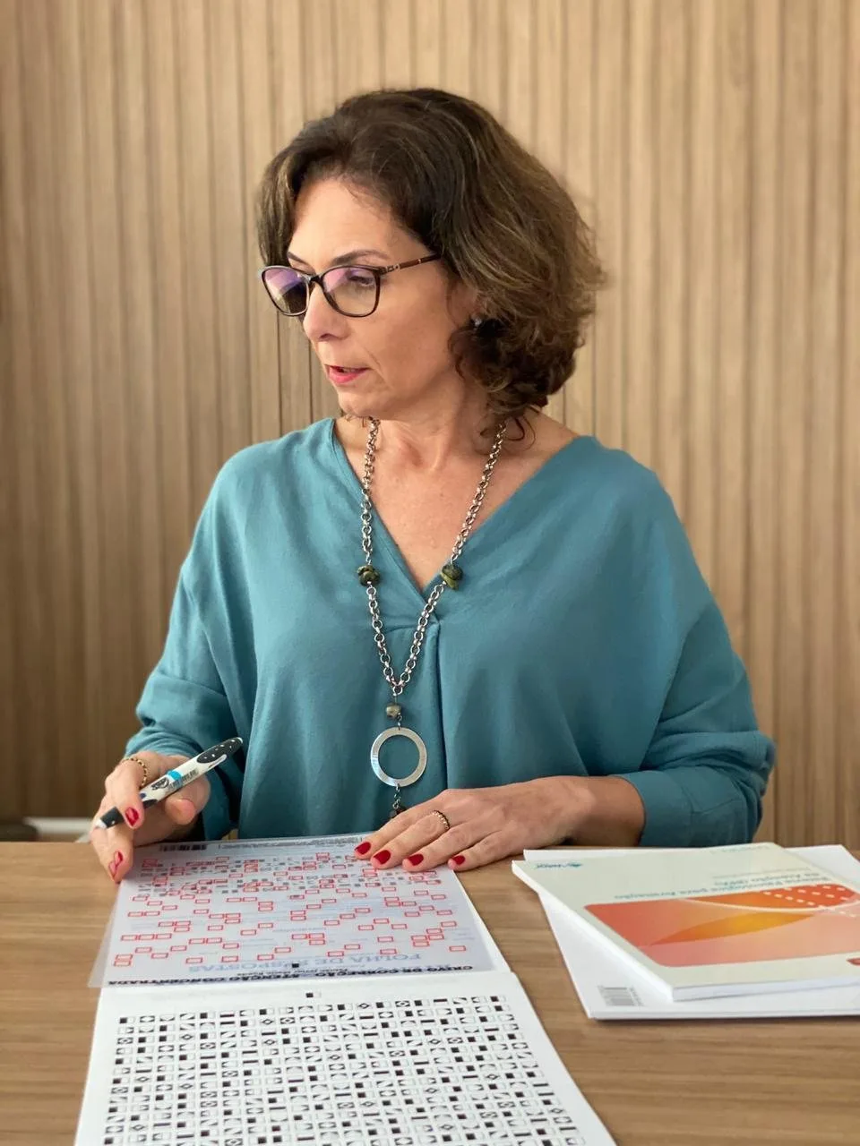 Gisela Mottin analisando um instrumento de avaliação neuropsicológica
