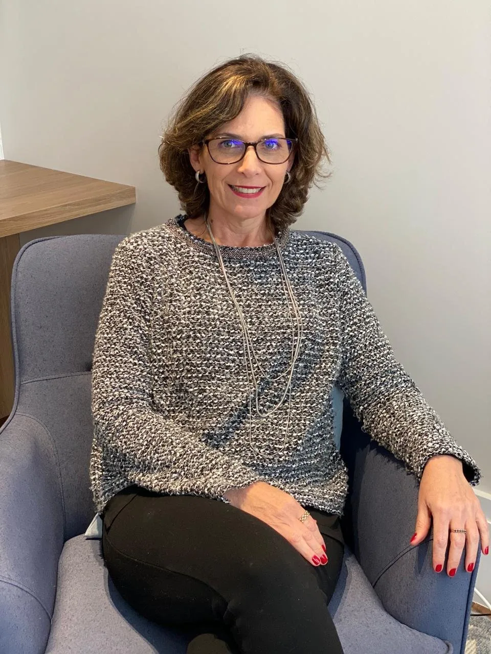 Gisela Mottin sentada na poltrona do consultório