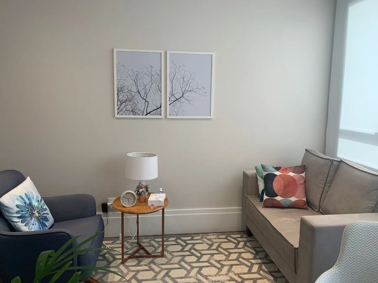 Sala de atendimento com sofá e mesa lateral